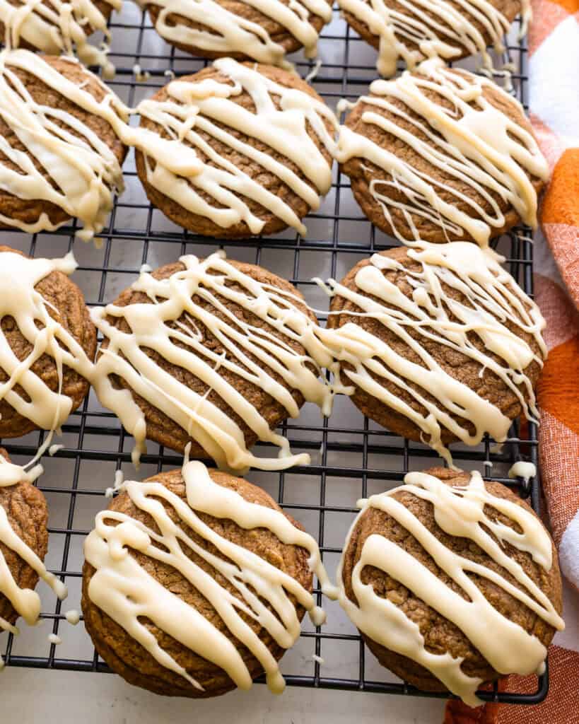 Maple glaze drizzled coffee cookies on a wire cooling rack. 