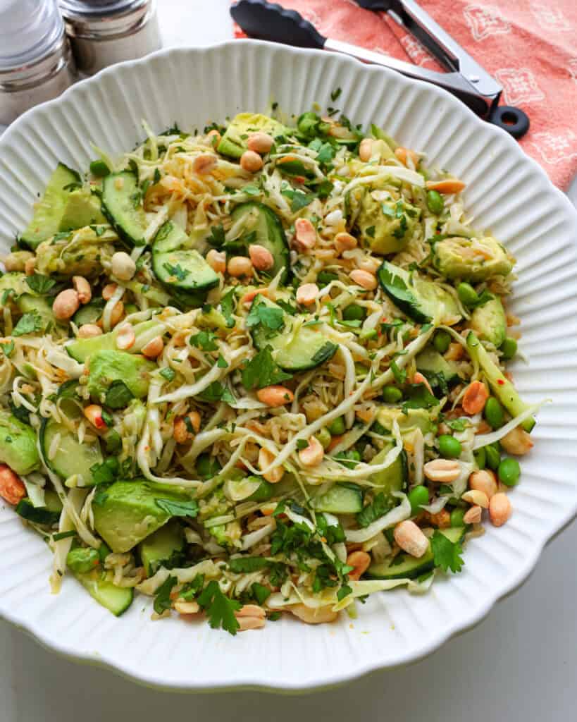 A close up view of crispy rice salad with peanuts, cucumbers, avocado, cabbage, and cilantro. 
