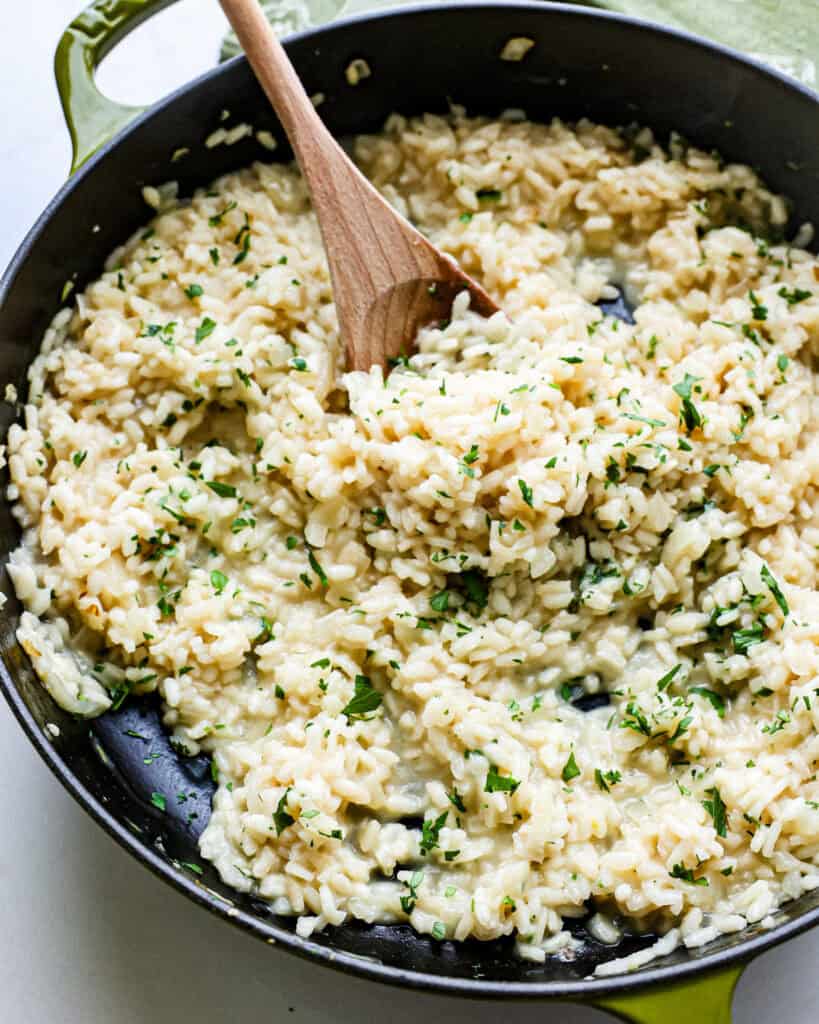A large green skillet full of Parmesan risotto.