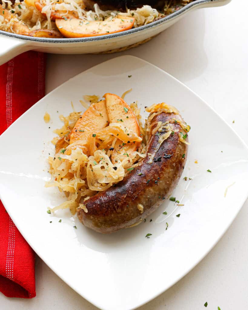 A single serving plate with bratwurst and sauerkraut. 