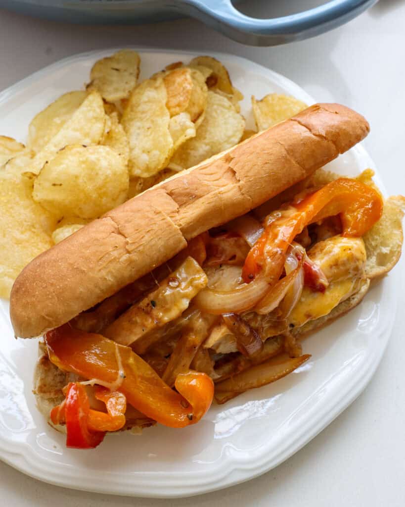 A close up view of chicken cheesesteak on a toasted sub roll.