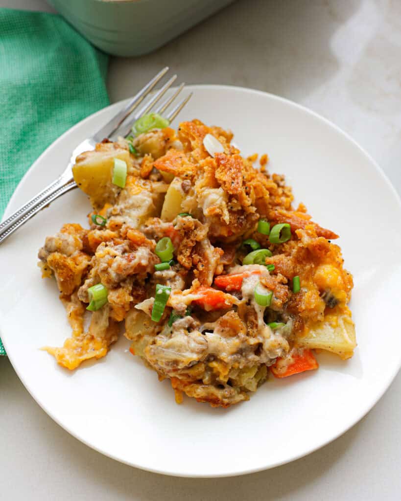 A single serving plate full of hobo casserole with a fork and green napkin in the background. 