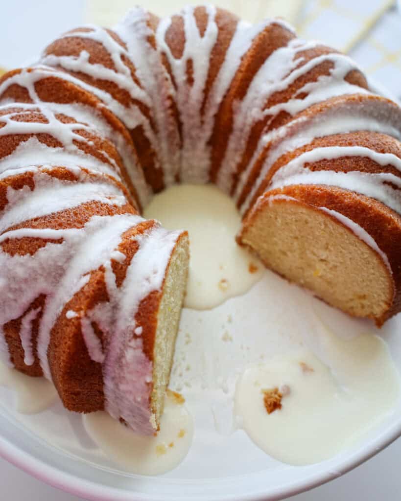 A cut lemon bundt cake on a cake stand. 
