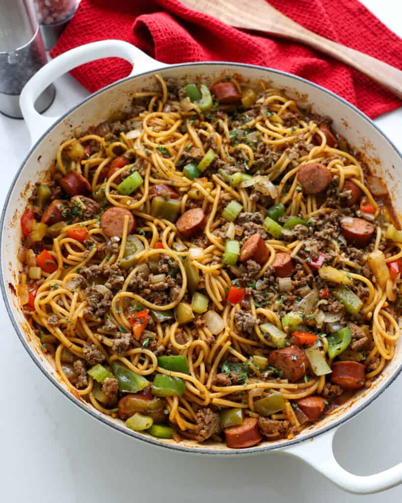 A close up view of a Durtch oven full of dirty spaghetti. 