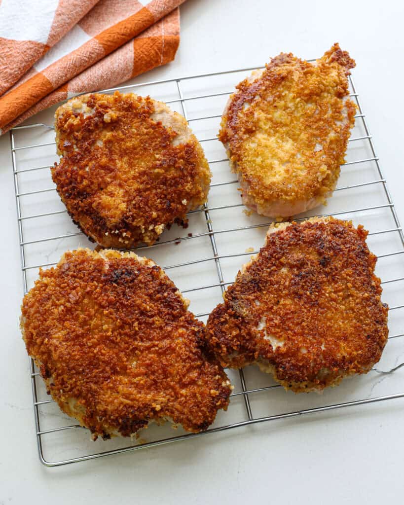 Parmesan crusted pork chops on a wire rack. 