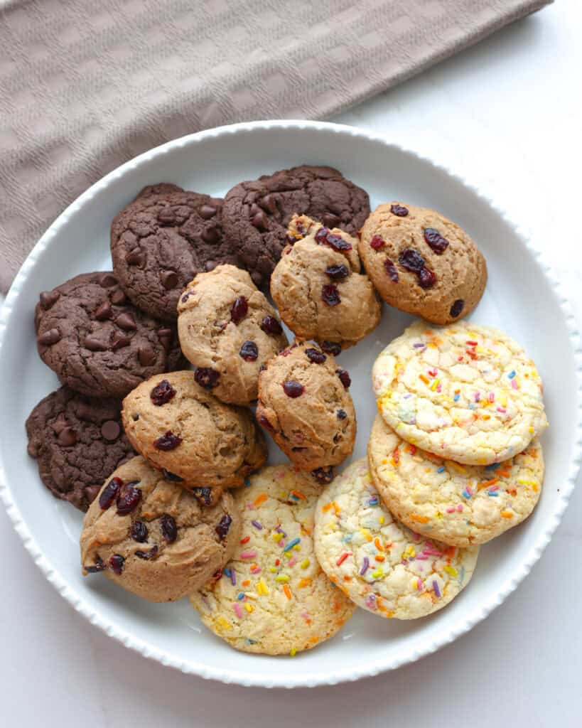 A white serving platter full of cake mix cookies, confetti, spice, and chocolate fudge cookies.
