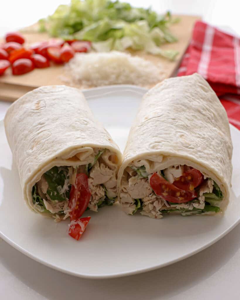 A close up view of a chicken Caesar wrap cut in half.