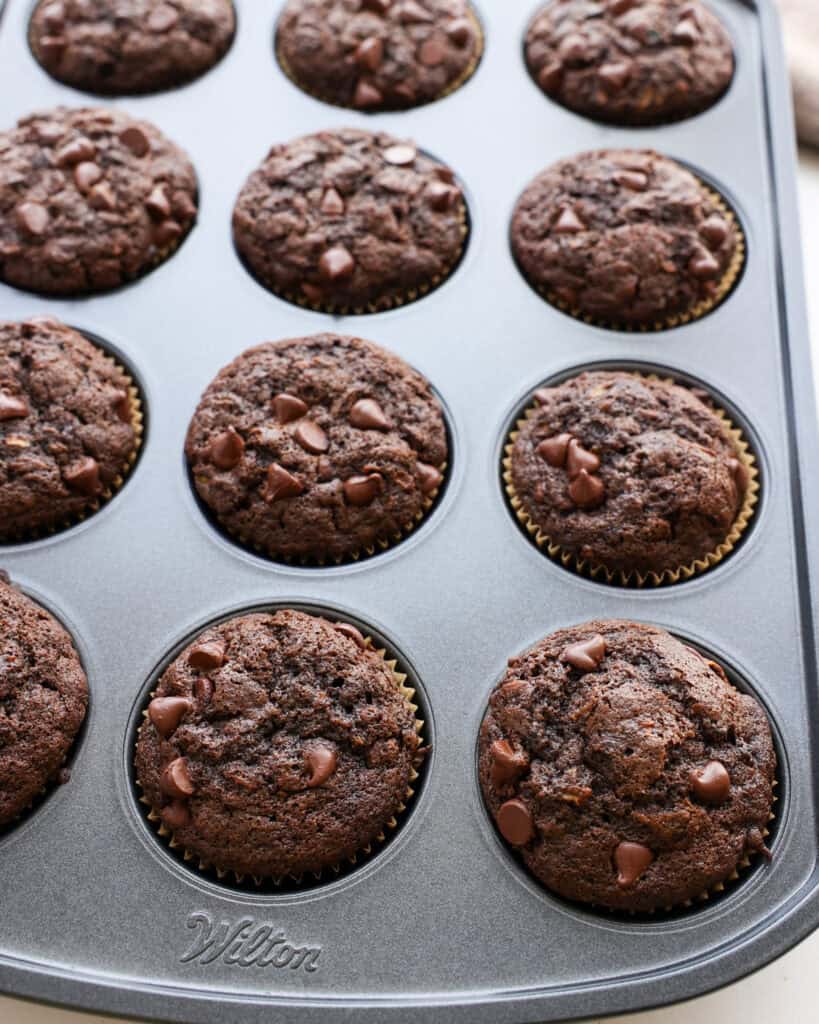 A tin full of freshly baked chocolate zucchini muffins.