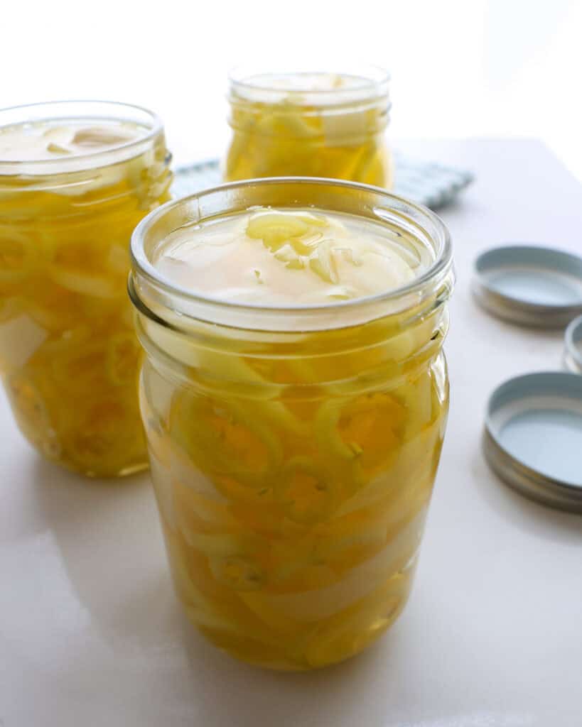 A close up view of mason jars of pickled banana peppers.