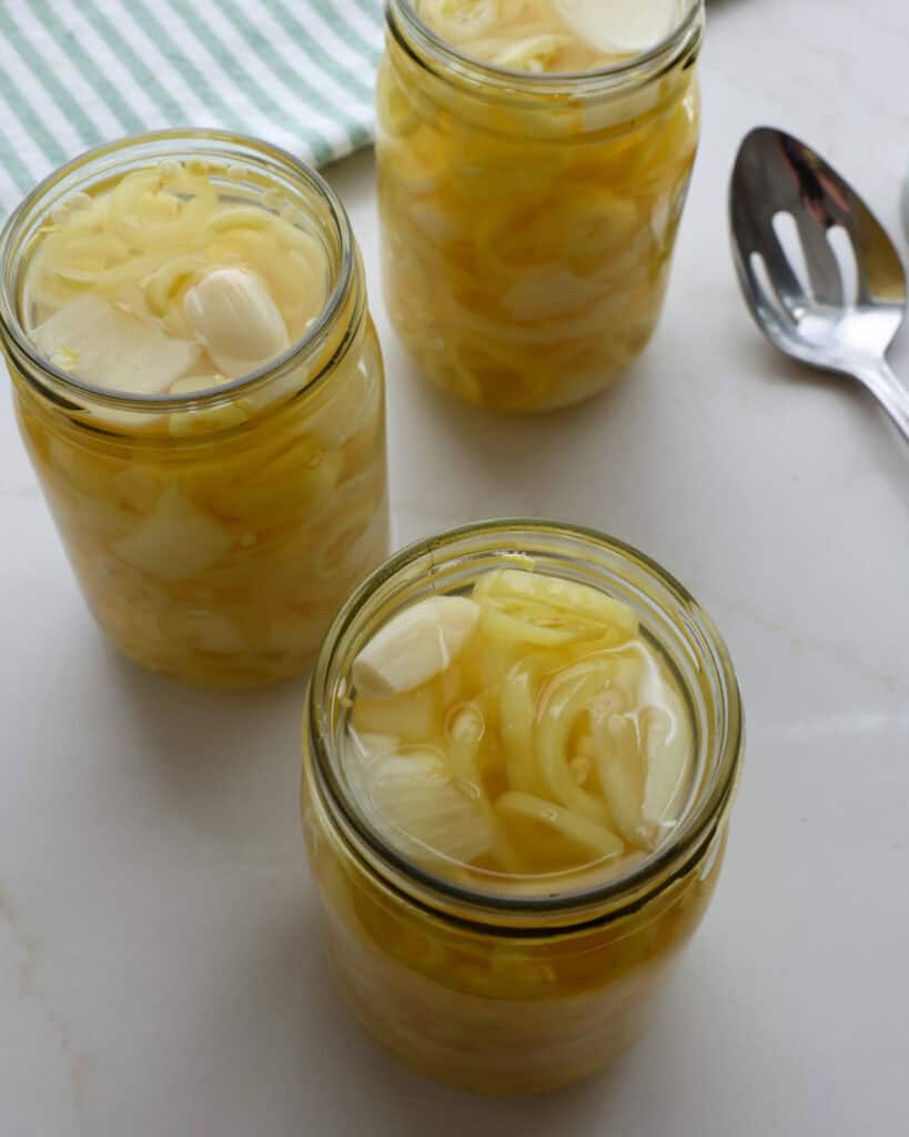 An overhead view of jars full of pickled banana pepperss