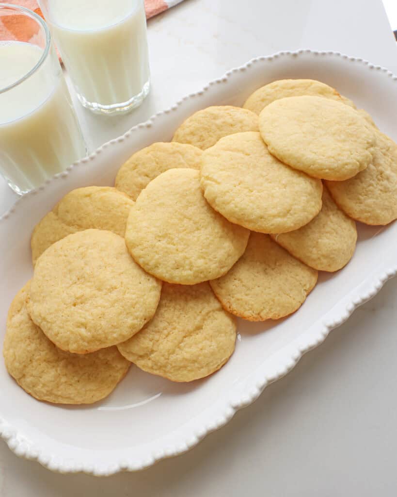 A close up view of tea cakes on a decorative white platter.