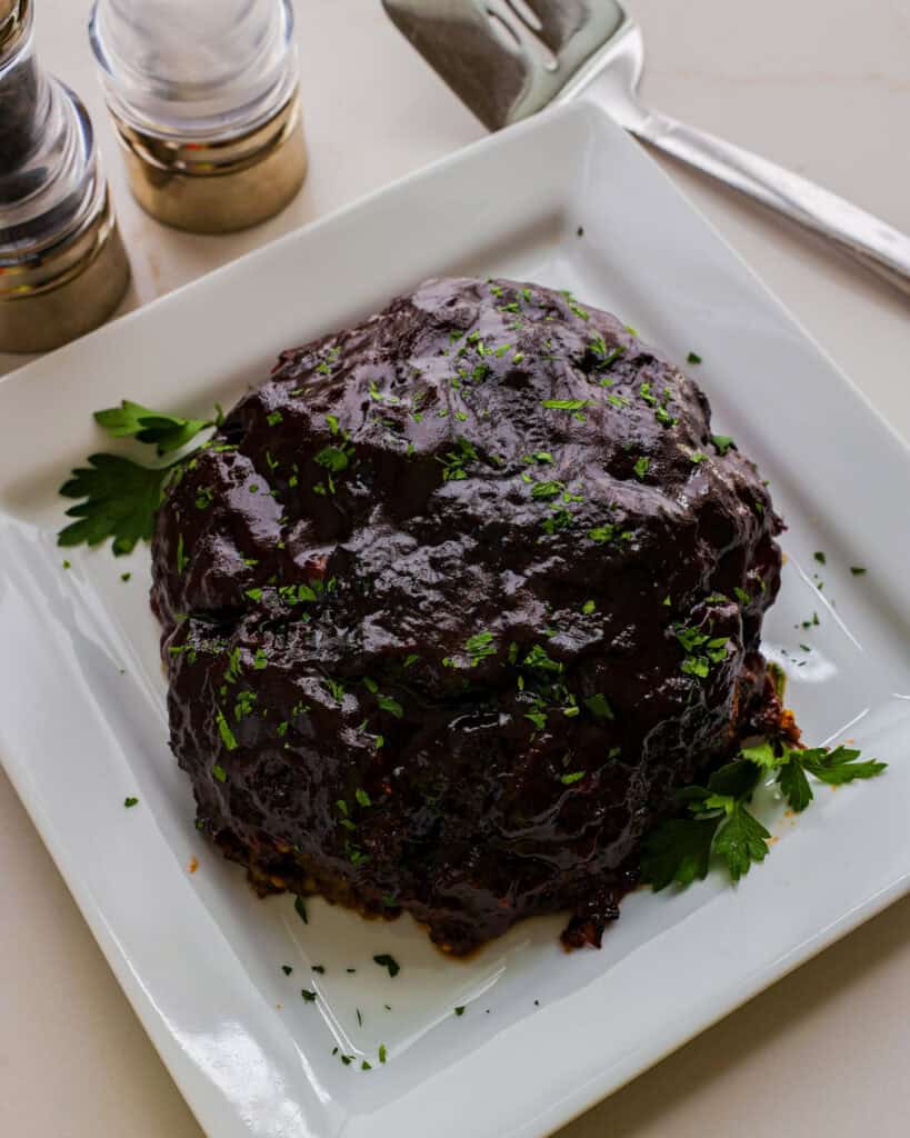 An overhead view of a whole air fryer meatloaf on a platter. 