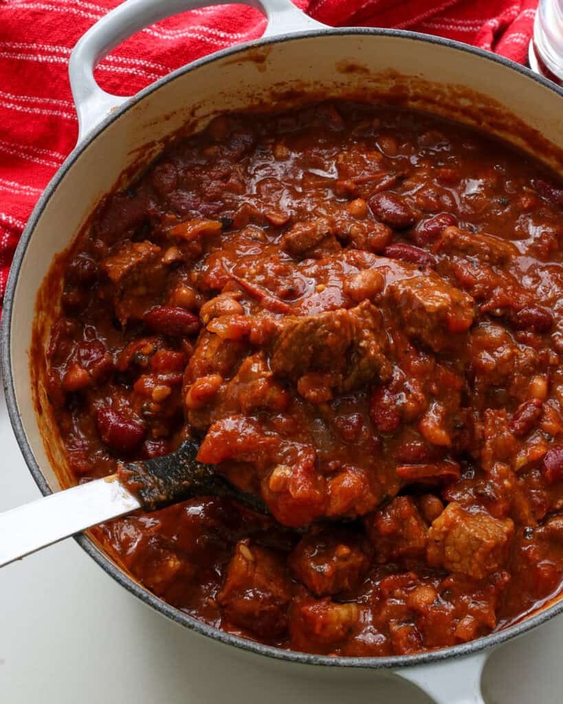 A large white Dutch oven full of brisket chili.