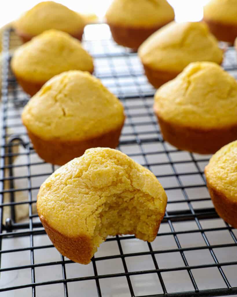 A close up view of a cornbread muffin on a cooling rack.