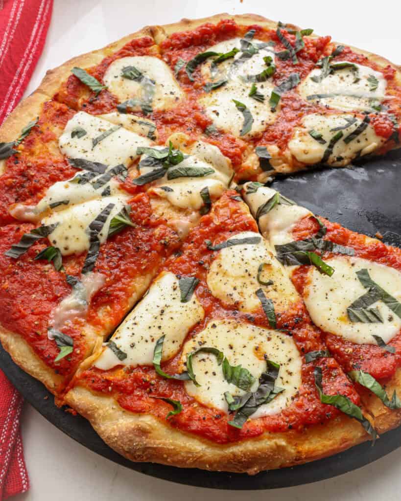 A freshly baked Margherita pizza on a pizza stone.