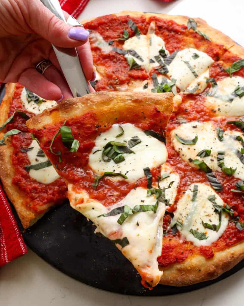 A slice of margherita pizza on a spatula.