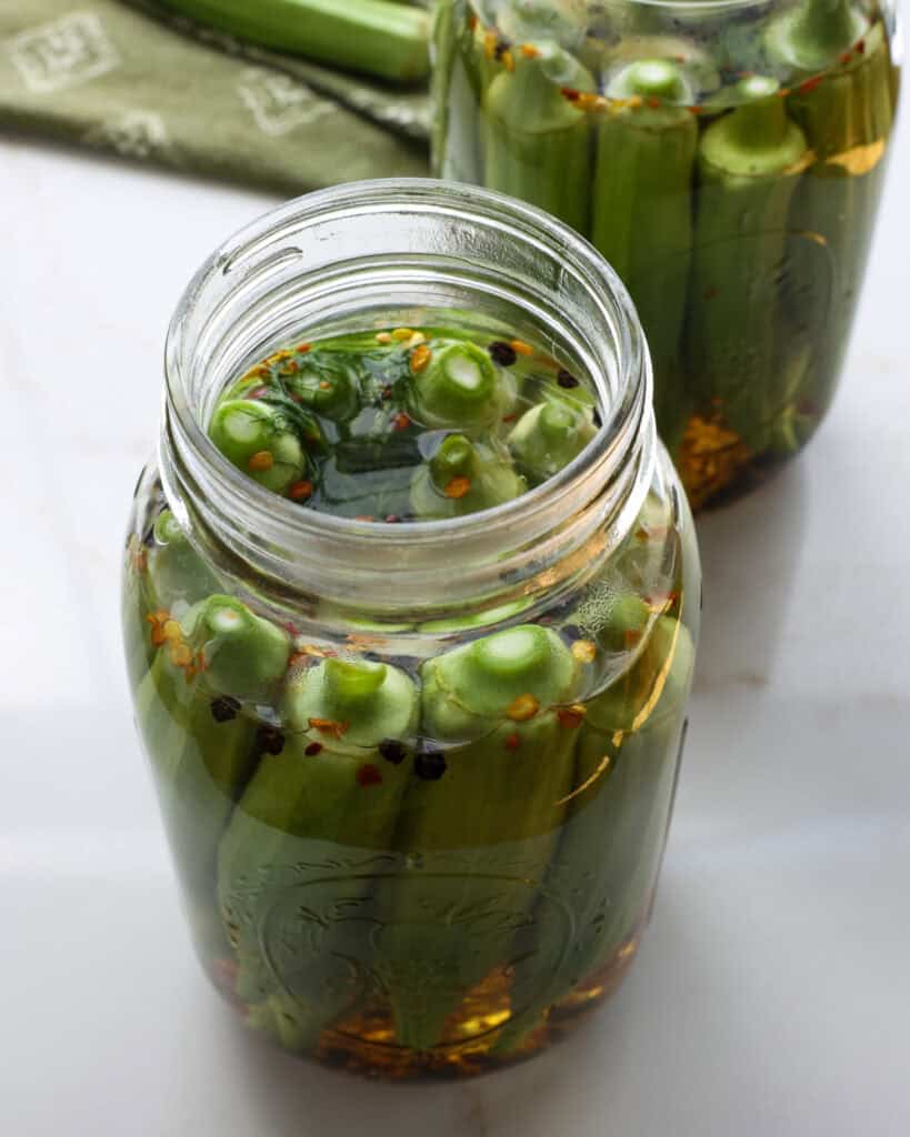 Two open mason jars with pickled okra