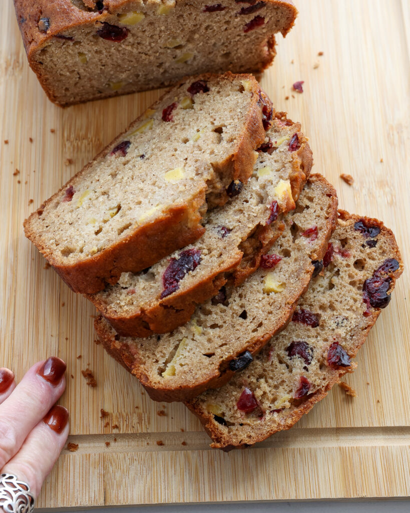 Four sliced of applesaue bread on a cutting board.