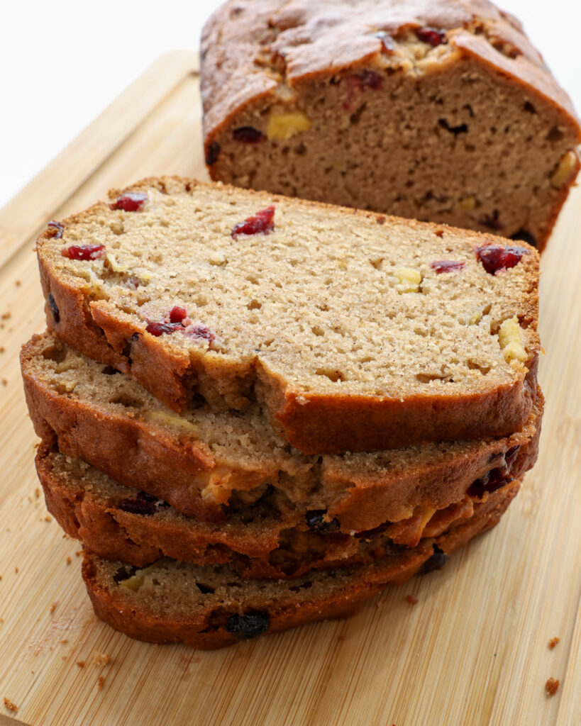 A close up view of four slices of applesauce bread stacked on a cutting board.