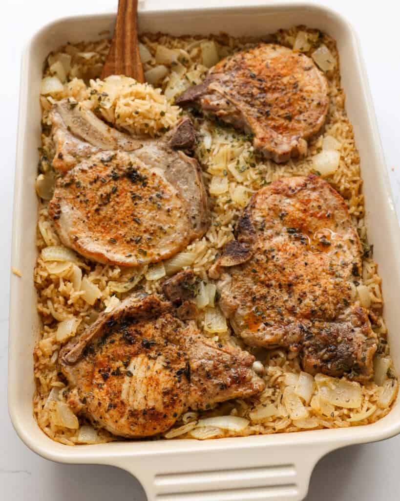 An overhead view of a 9x13-inch dish full of pork chops and rice.