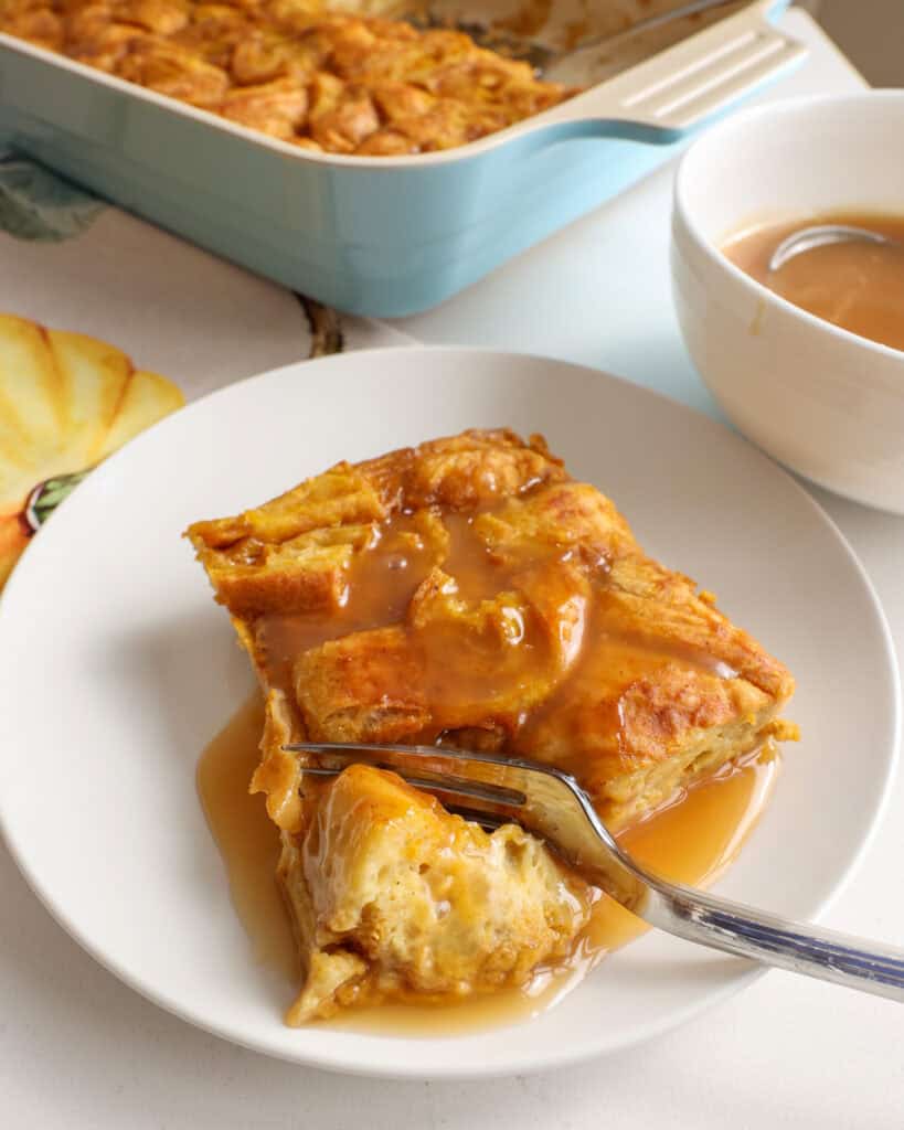 A piece of pumpkin bread pudding with a bite on a fork. 